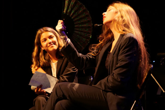 Deux jeunes femme jouant une pièce de théâtre sur scène.
