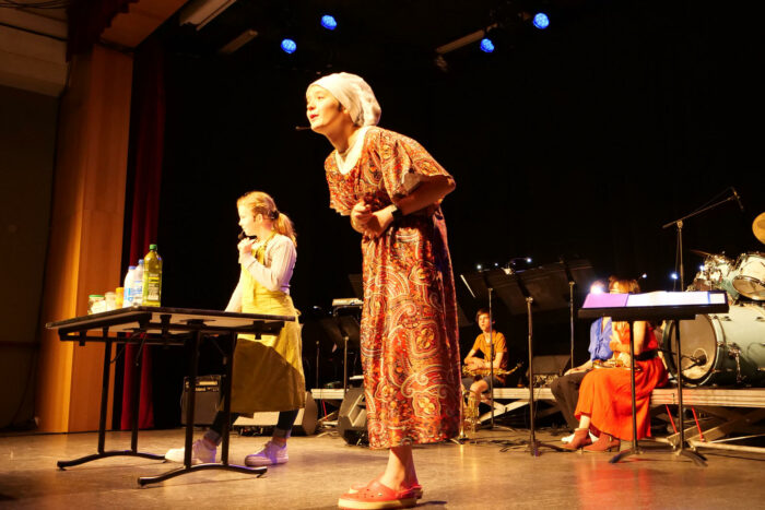 Plusieurs jeunes interprète une pièce de théâtre en public.