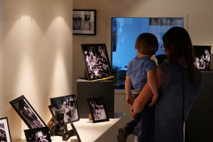 Une femme et un enfant regarde une exposition d'anciennes photographies.