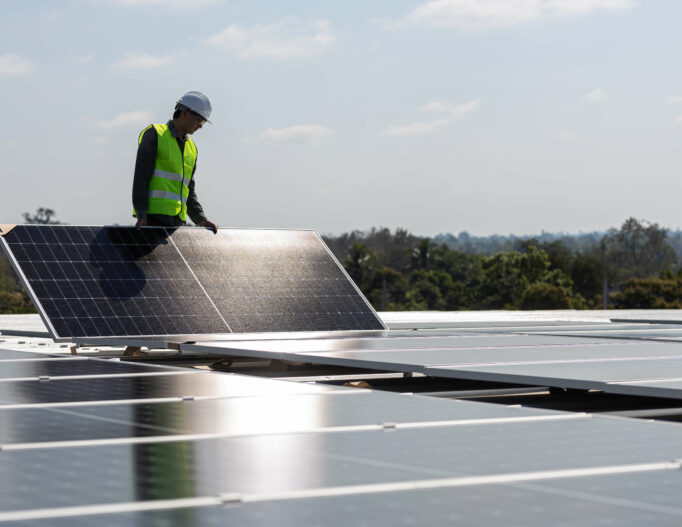 Photo d'un agent installant des panneaux photovoltaïques